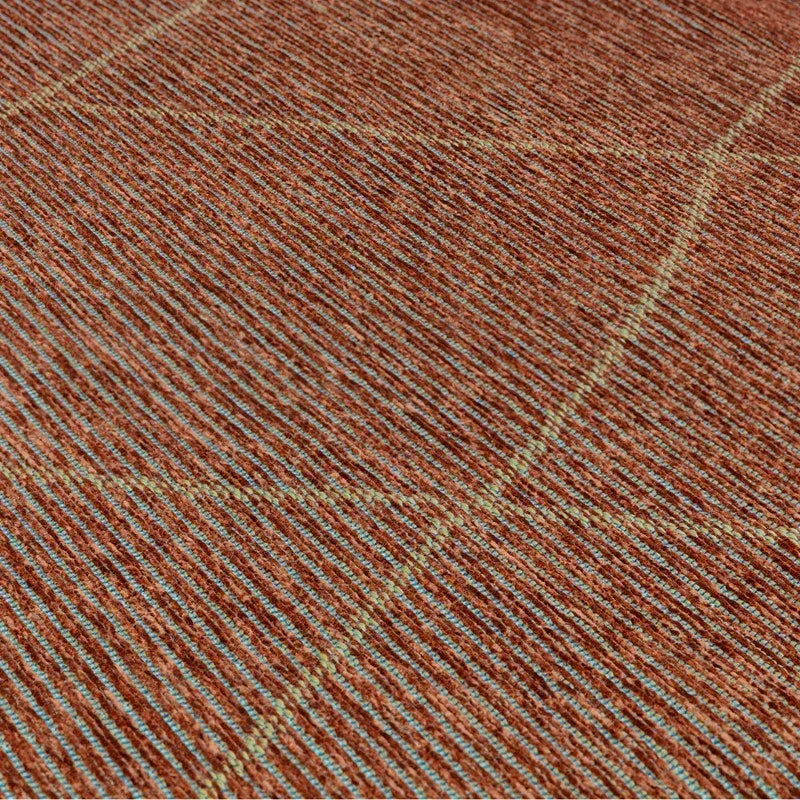 Closeup of textured orange and cream woven rug surface with diagonal stripe pattern