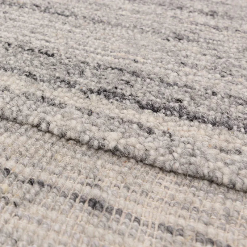 Close-up of grey wool rug texture with subtle woven pattern