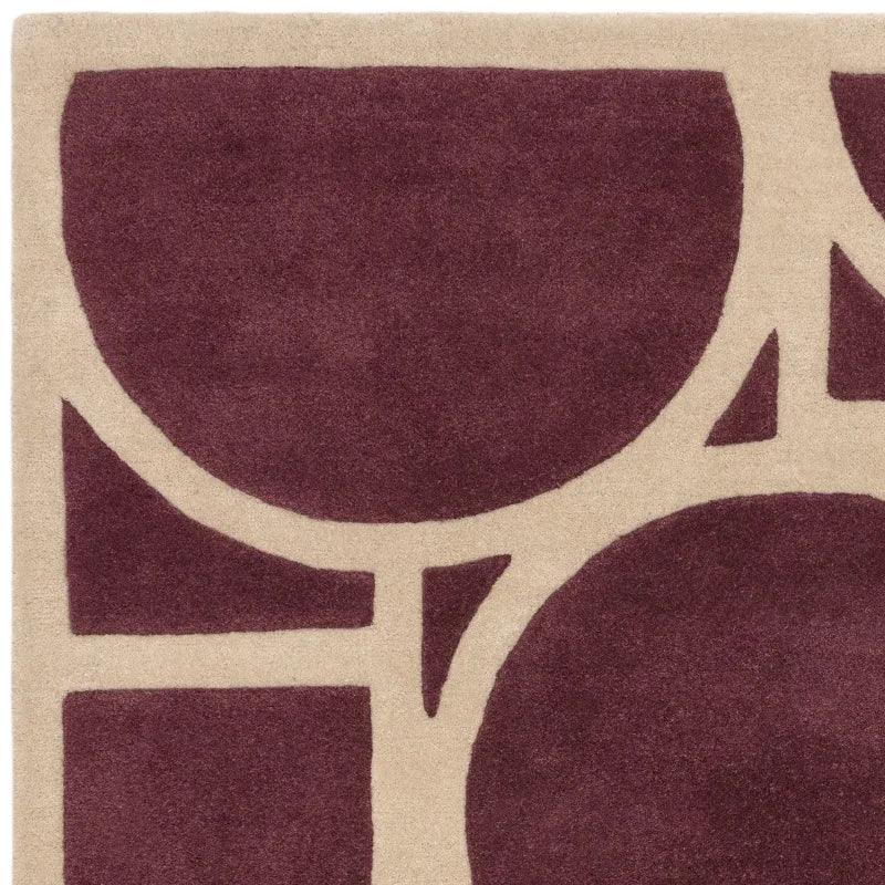 Plum geometric rug corner with beige abstract pattern and textured wool pile