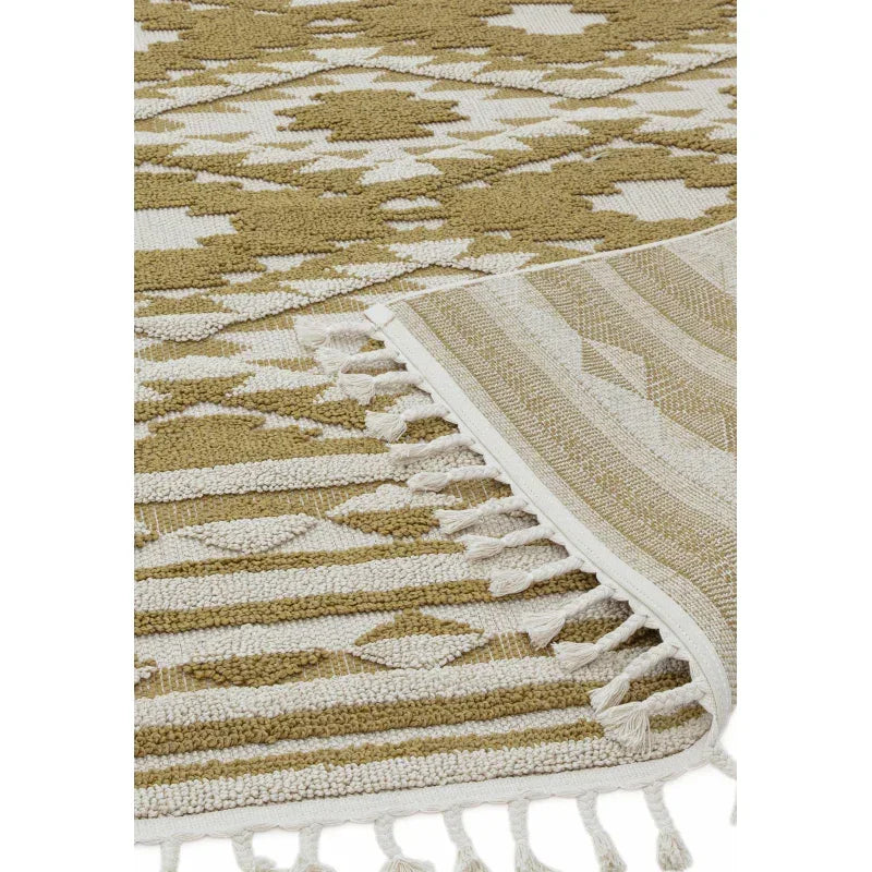 Beige and white geometric patterned rug with fringed edge, close-up of texture and weave