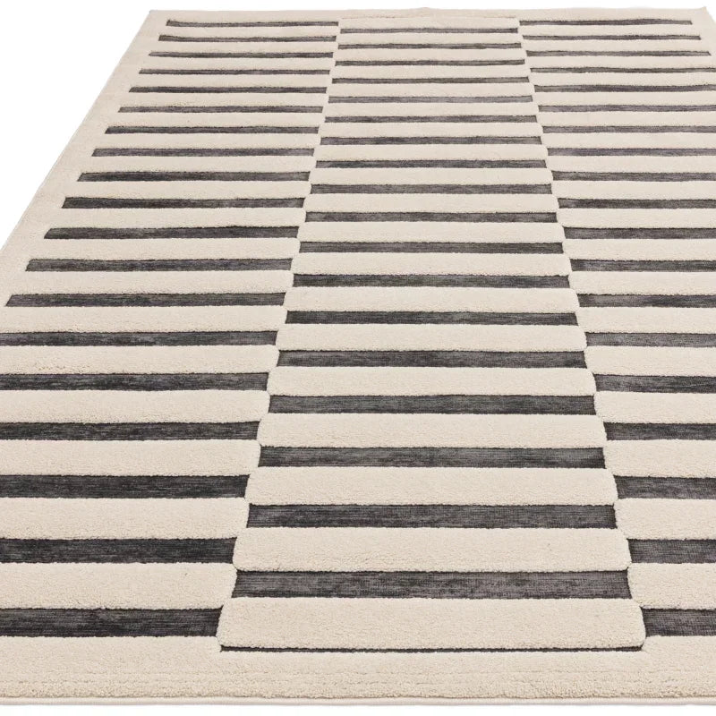 Modern area rug with black and cream geometric stripe pattern