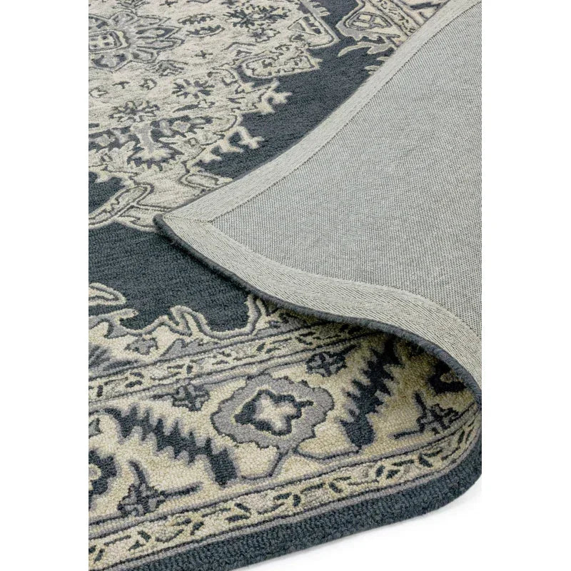 Traditional patterned area rug in grey and cream with visible backing and corner detail