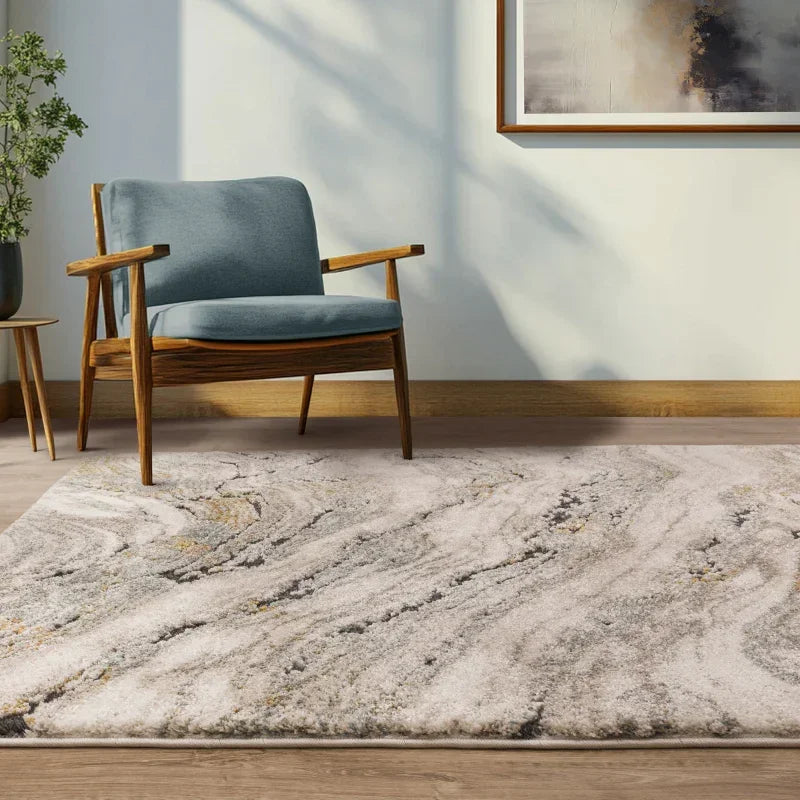 Modern accent chair with light blue cushions on a textured grey marble pattern rug