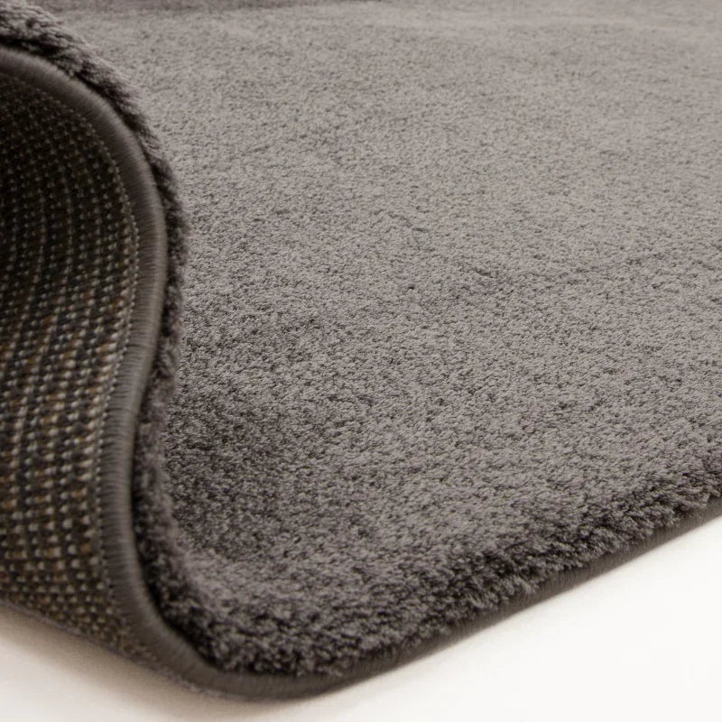 Close-up of grey rug with soft pile and textured non-slip backing