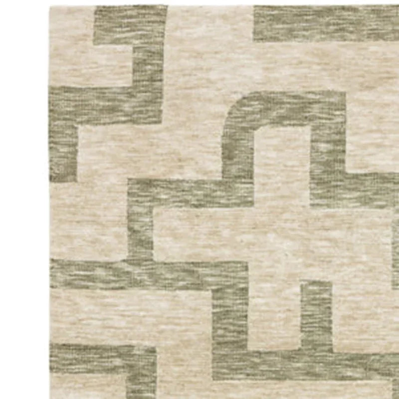 Beige and green geometric pattern rug corner close-up, textured soft pile