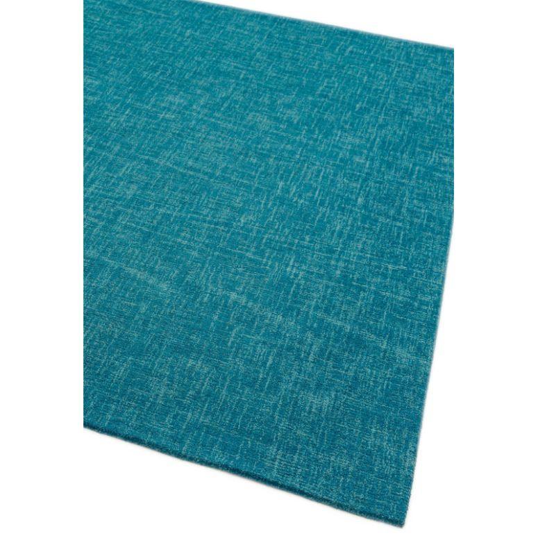 Teal blue area rug with subtle textured weave, close-up angle