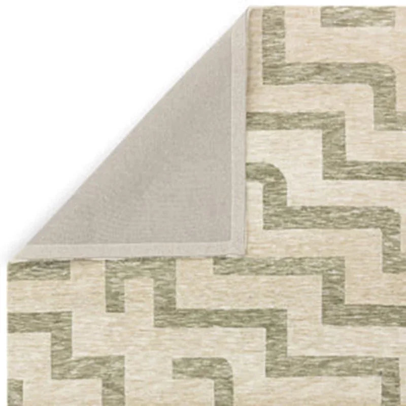 Beige and green geometric pattern rug with corner folded to show backing