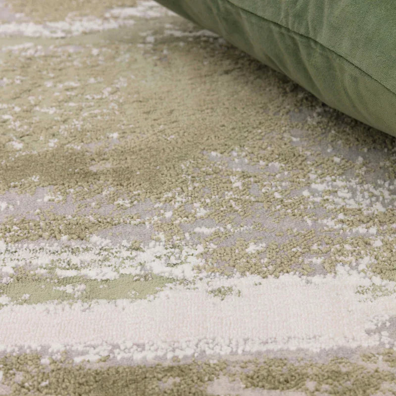 Close up of soft green patterned rug with textured surface and subtle cream accents