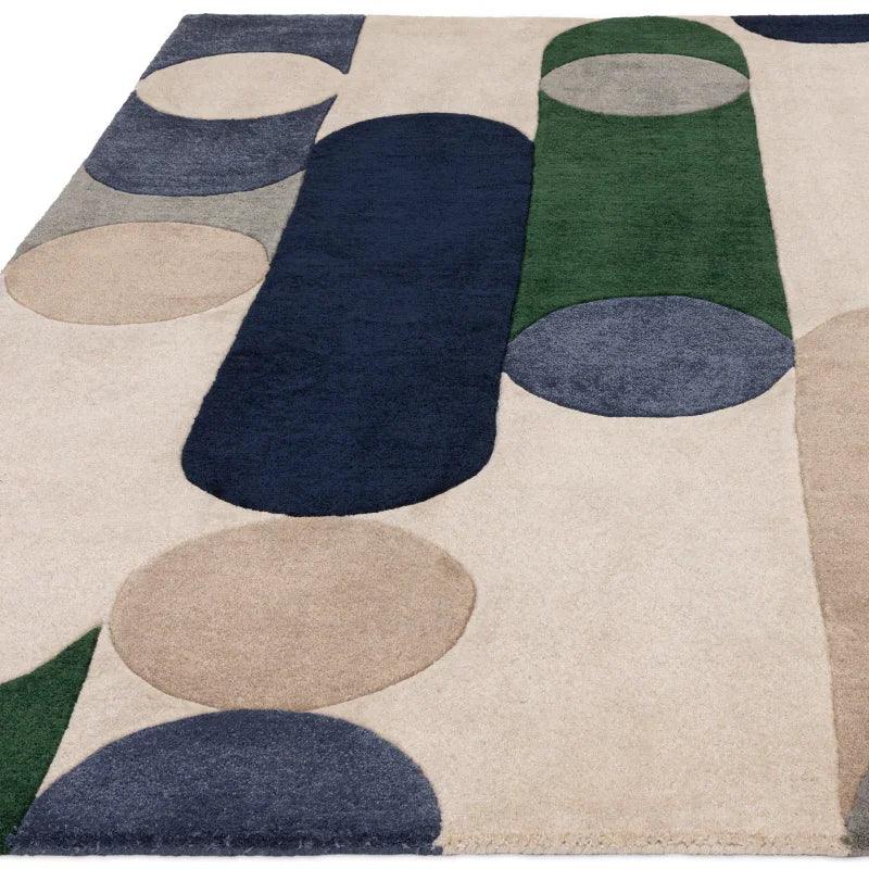 Modern geometric rug with navy, green, beige and grey shapes on a cream background