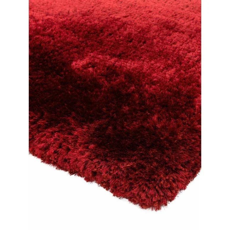 Deep red shaggy rug corner with thick pile texture