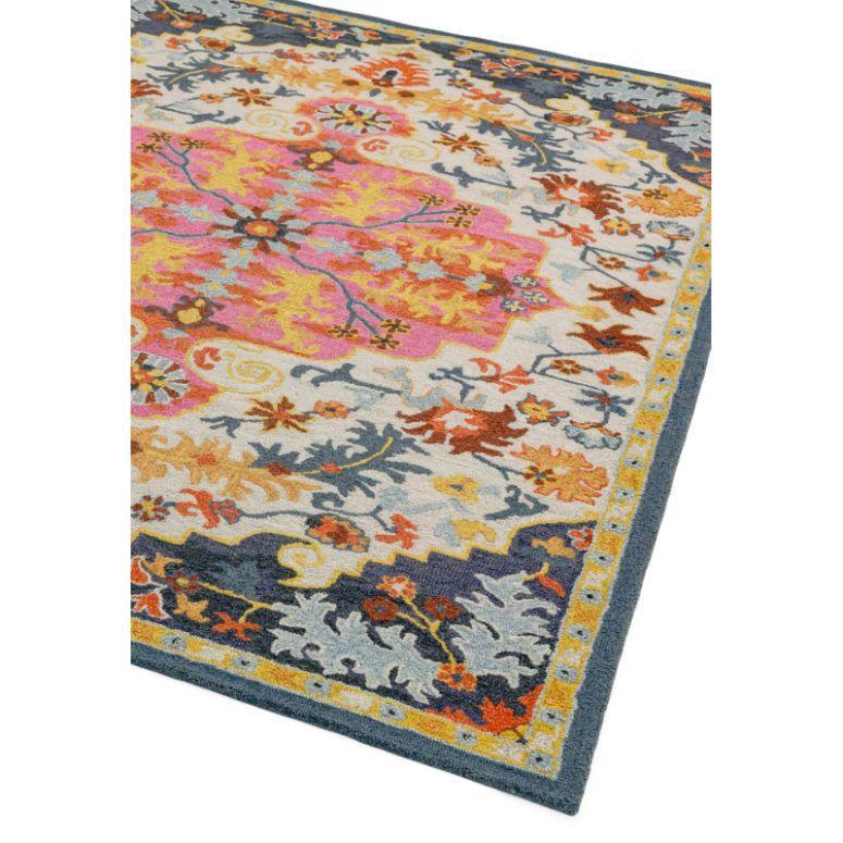 Colorful floral area rug with blue border and pink medallion design, corner view