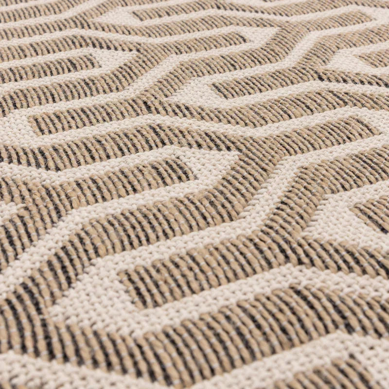 Textured beige and cream area rug with geometric zigzag pattern, close-up view