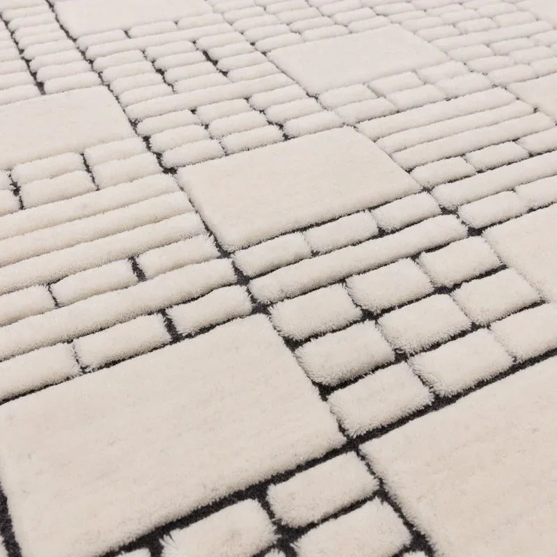 cream geometric area rug with raised rectangular pattern and black accents