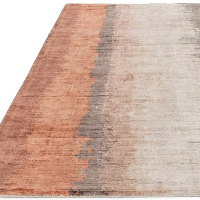 Contemporary area rug with gradient rust, grey and beige tones on a flat surface