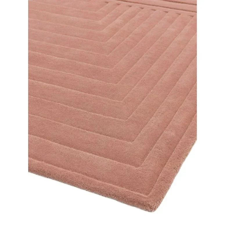 Blush pink geometric patterned rug with raised textured lines, close corner angle view
