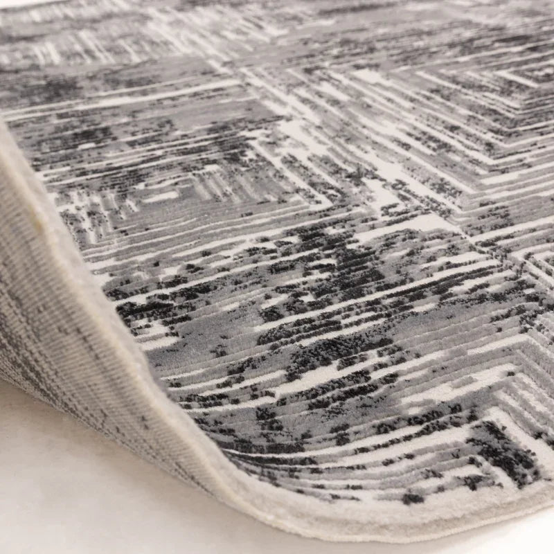 grey modern area rug with abstract linear pattern and textured pile detail