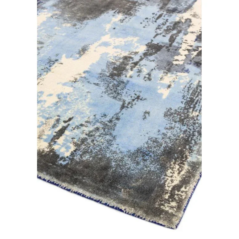 blue and grey abstract area rug with textured surface and soft edges