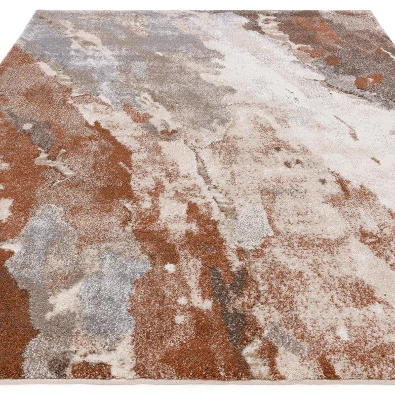 Modern abstract area rug with brown, beige and grey tones on textured surface