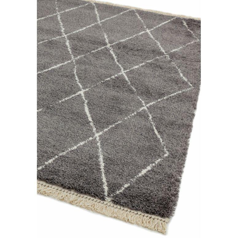 Grey area rug with white diamond pattern and fringed edge corner view