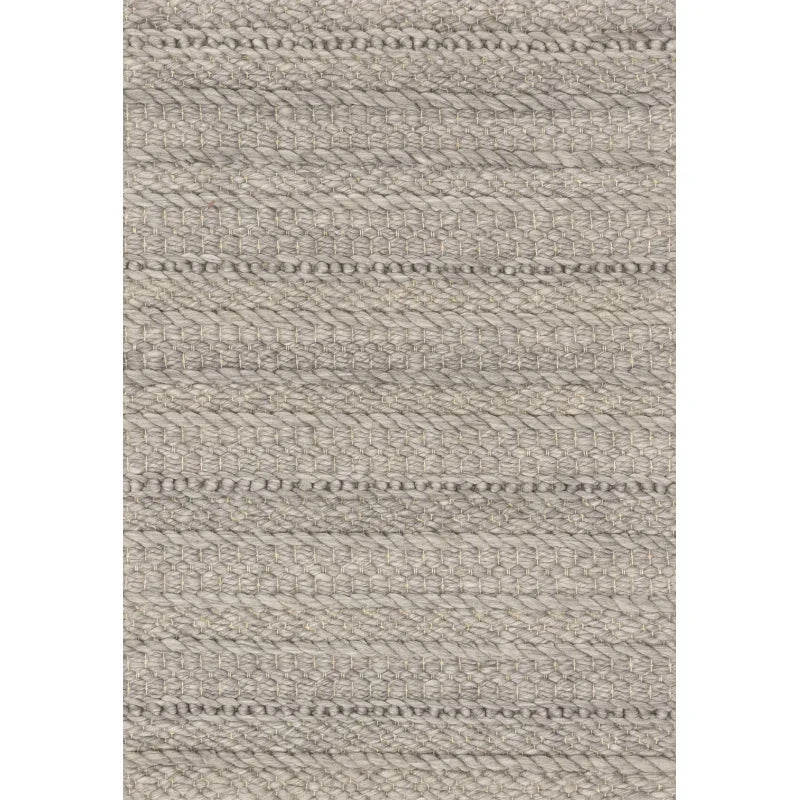 Closeup of textured grey woven rug with thick braided wool pattern