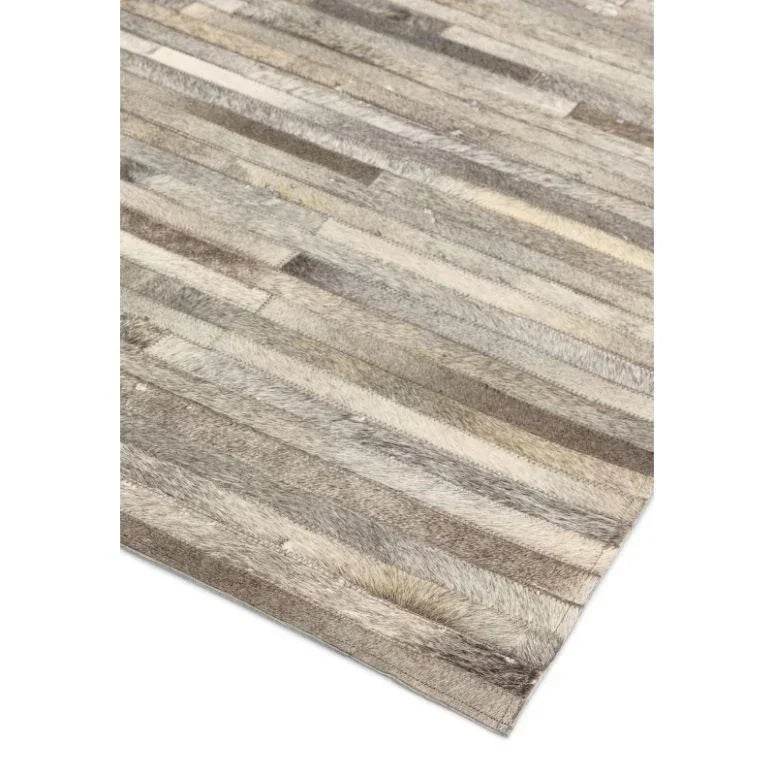 Grey and beige patchwork rug with textured striped design on a white background
