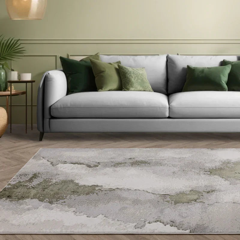 Modern grey fabric sofa with green throw pillows and abstract area rug in living room