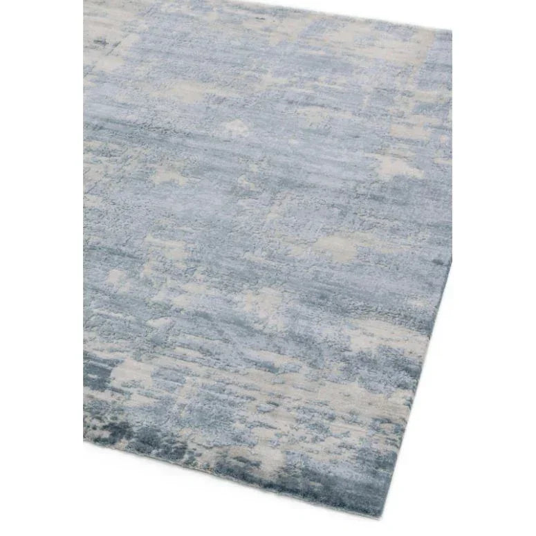 Grey and cream area rug with abstract textured pattern, close view of corner