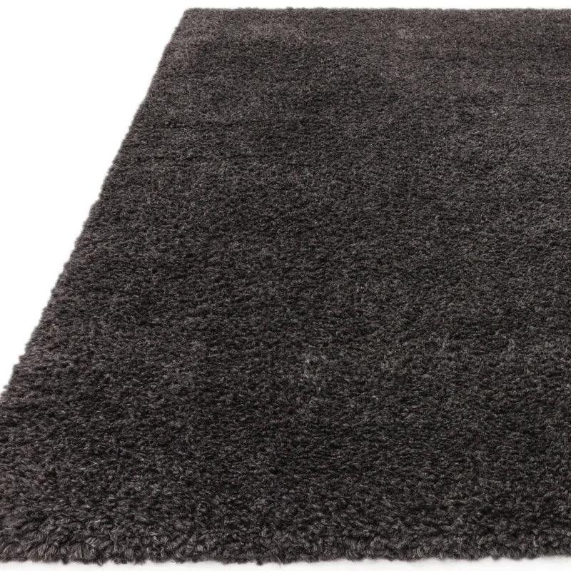 Dark grey shaggy rug with thick pile texture, close corner view