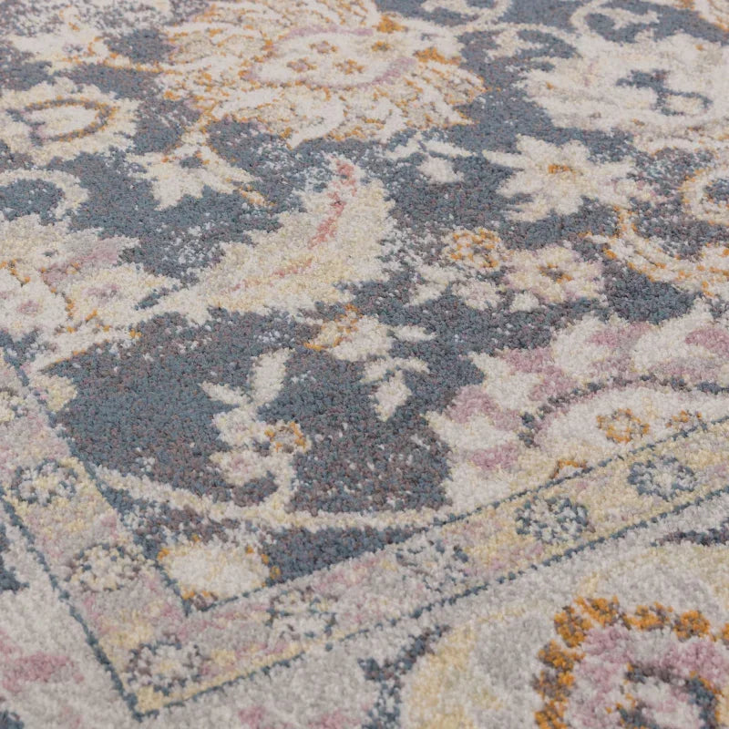 Close up of patterned area rug with blue, cream and gold floral design