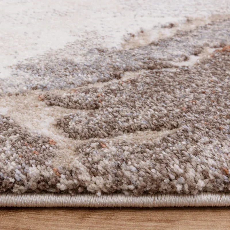 Closeup of textured beige and grey rug on wooden floor