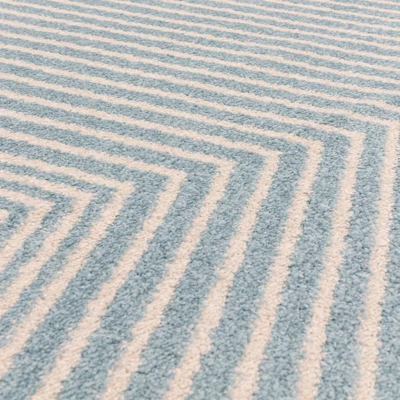 Closeup of blue and white striped area rug with soft textured surface and geometric pattern