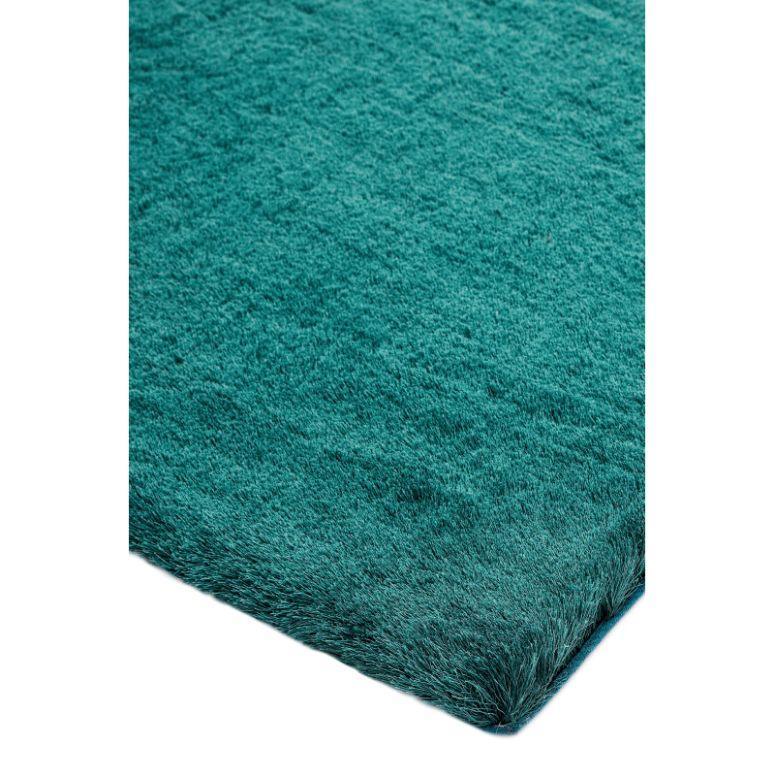 Teal shaggy rug corner showing soft pile texture and thick border detail