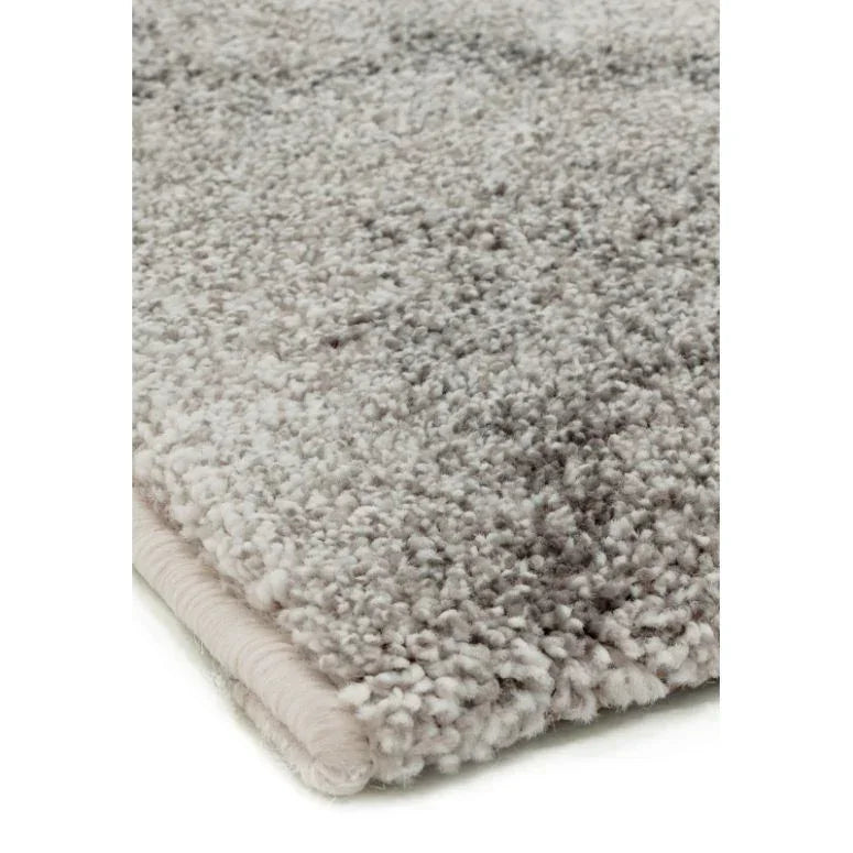Close-up of plush light grey shaggy rug showing soft texture and finished edge