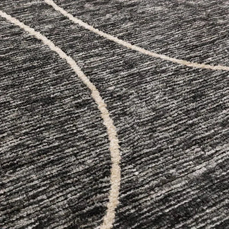 Grey textured rug with cream curved line detail, close-up of modern carpet design