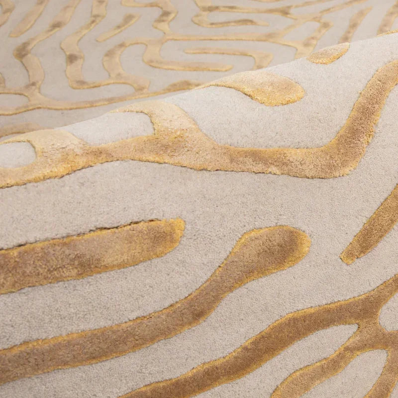 Close view of beige and gold patterned rug with raised textured design