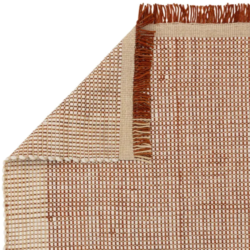Rectangular woven rug with brown and cream check pattern and fringe edge detail