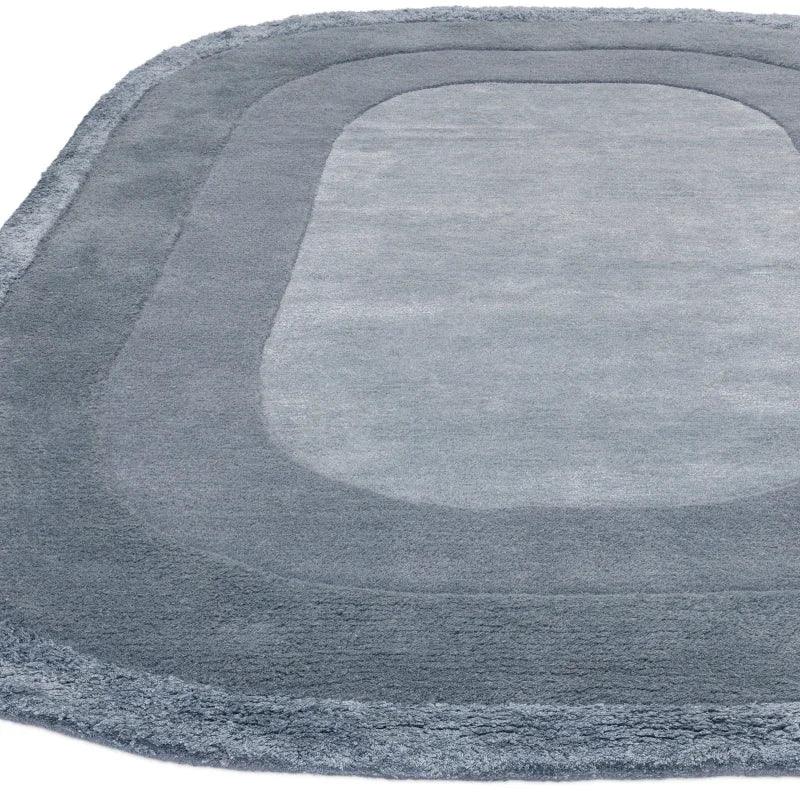 Grey rectangular rug with rounded corners and layered border design