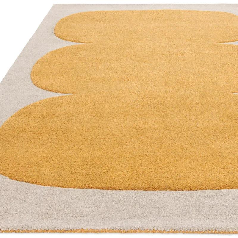 Modern yellow and beige area rug with abstract scalloped design, close view of texture