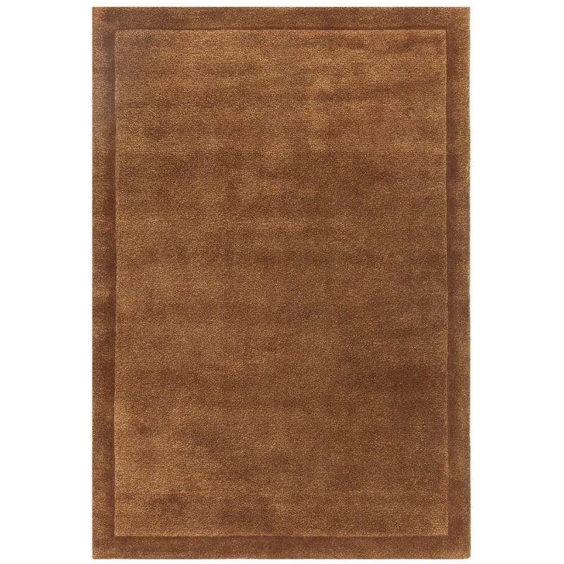 Brown rectangular area rug with subtle border pattern and soft texture