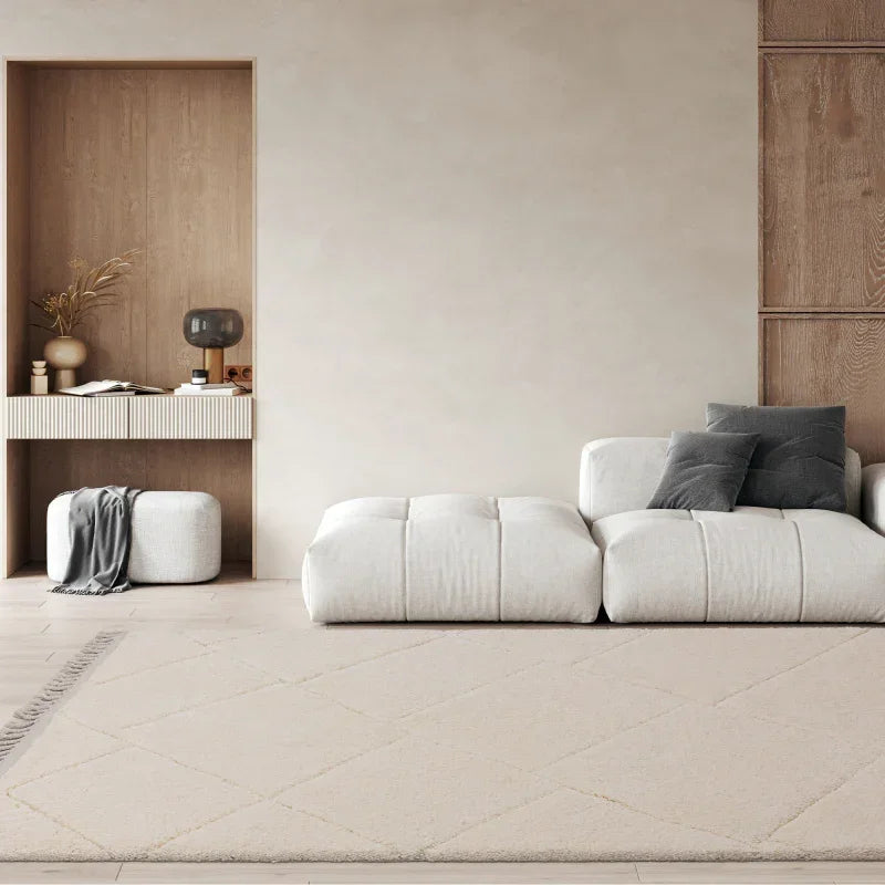 Modern cream area rug in living room with white sectional sofa and grey accent pillows