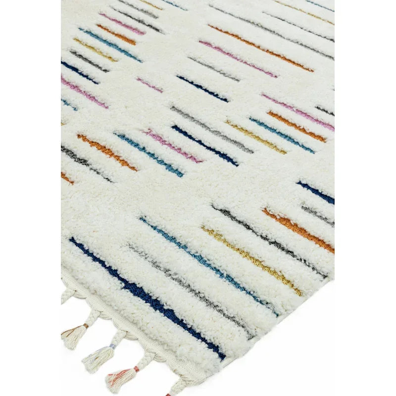 White shaggy rug with multicolour stripes and tassels, close view of corner texture