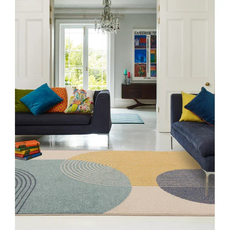 modern living room with geometric area rug, navy sofas, and colorful cushions