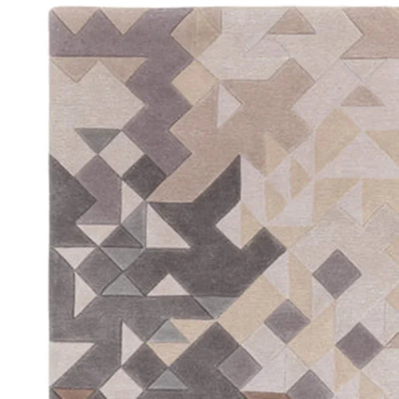 Geometric patterned area rug in grey and beige tones, closeup of corner design