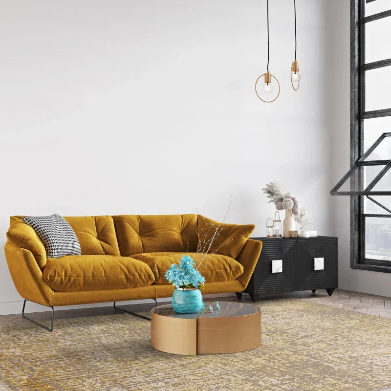 Mustard velvet sofa with black metal legs in modern living room, round coffee table in front