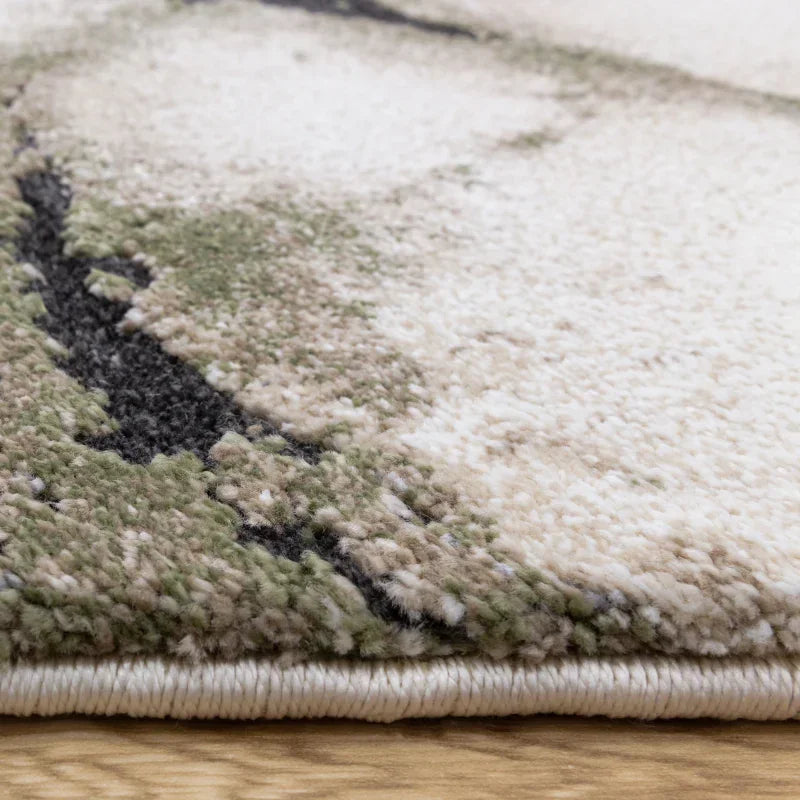 Closeup of modern area rug with abstract green, beige, and grey pattern on wood floor