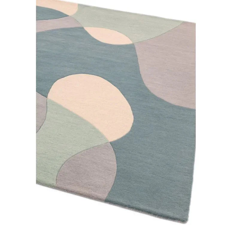 Modern area rug with blue, green, and cream abstract pattern, corner view