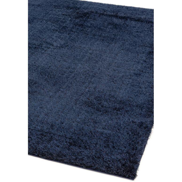 Navy blue shaggy rug with soft textured pile, close corner view