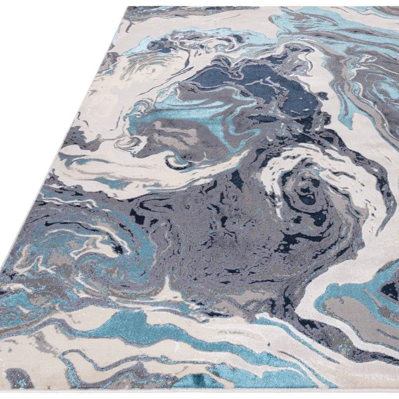 Modern area rug with abstract blue, grey, and white marble swirl pattern