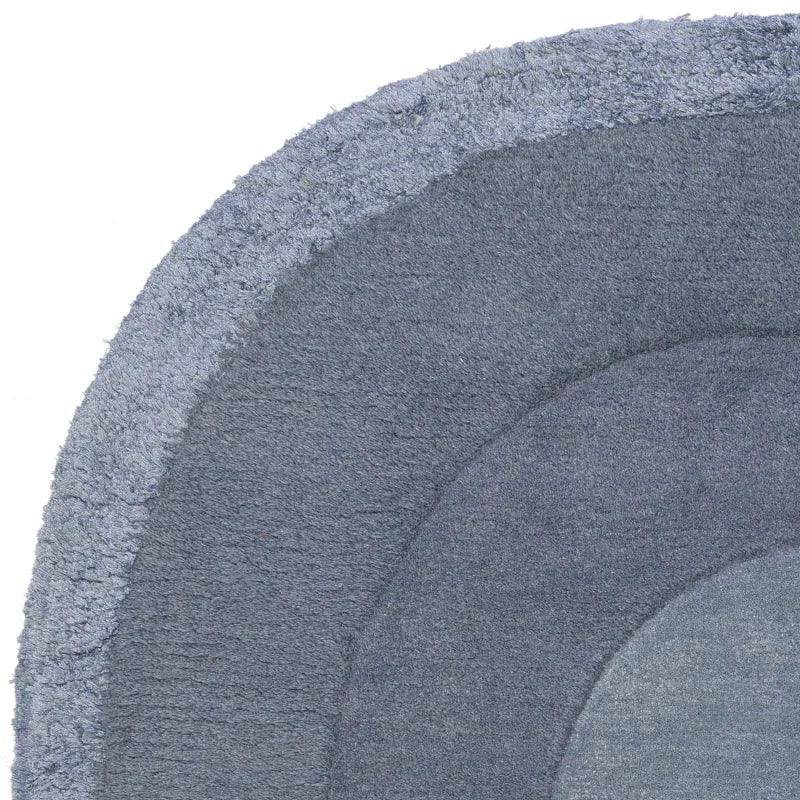 Closeup of round blue area rug with layered textured rings