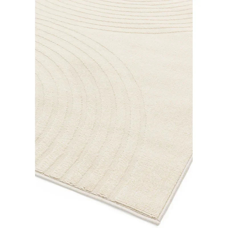 Cream textured area rug with subtle curved line pattern, close-up of corner view